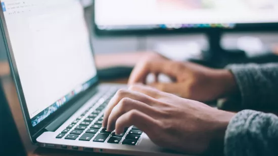 Un usager saisit du texte sur un clavier d'ordinateur