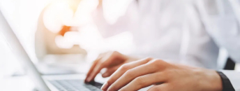 Un soigne tape sur un clavier d'ordinateur portable
