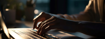 Une femme tape sur le clavier de son ordinateur portable